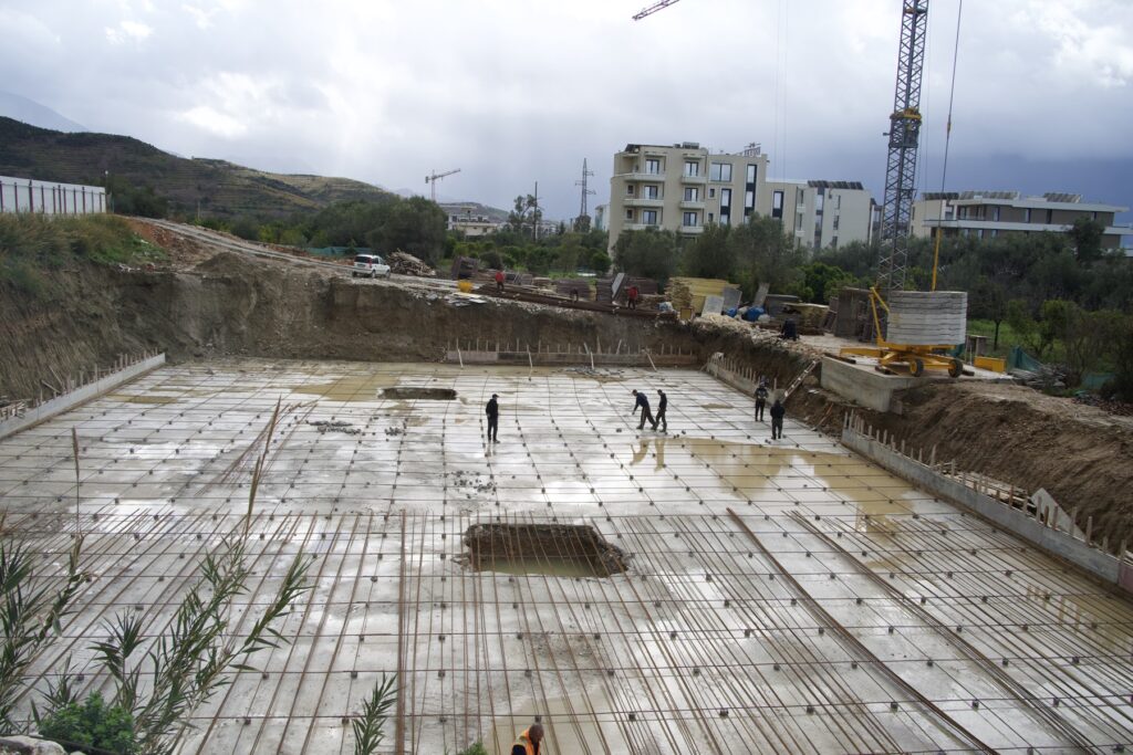 Overview of the reinforced foundation slab at Radhimë with the crane behind