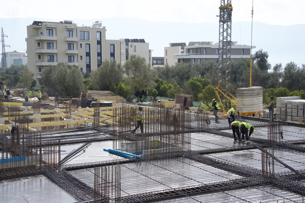 Foundation slab with tower crane and crew at the Radhimë development